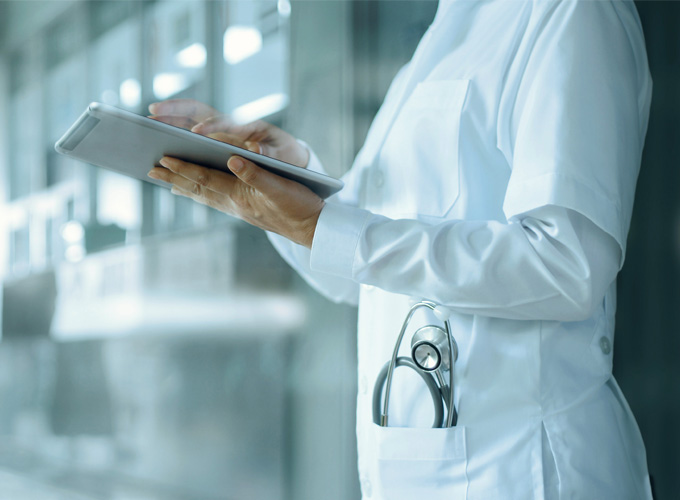 Medico che lavora su tablet su sfondo ospedaliero Medico che lavora su tablet su sfondo ospedaliero